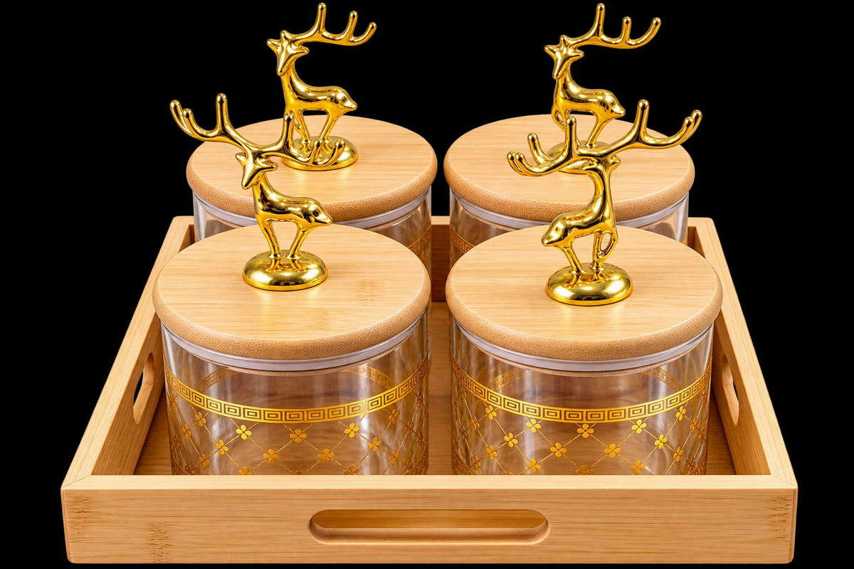 Set of four glass jars with golden reindeer figurine lids arranged on a natural wooden tray against a black background