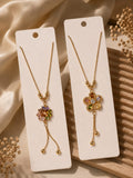 Two golden floral charm necklaces with multicoloured crystal flower pendants and tassel drops displayed on white jewellery cards