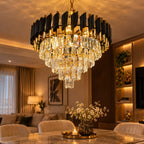 Close-up of multi-tiered crystal chandelier with black and gold frame illuminating a luxury living room